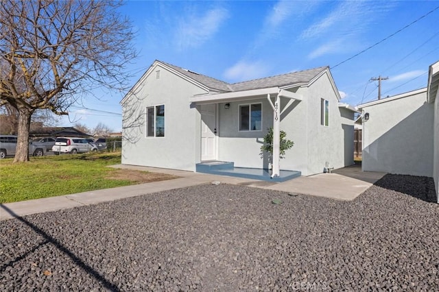 back of property featuring a yard and stucco siding