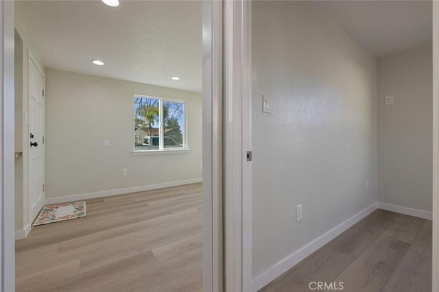 corridor featuring recessed lighting, light wood-type flooring, and baseboards