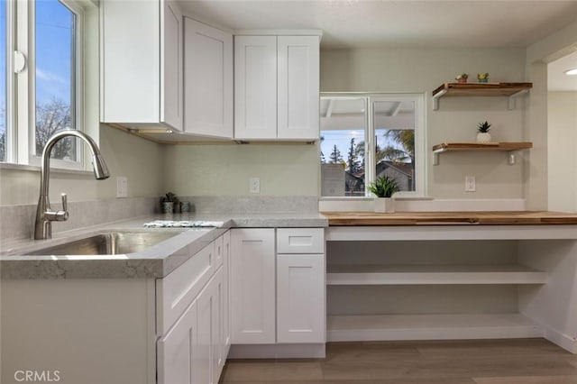 kitchen with a sink, open shelves, plenty of natural light, and white cabinets