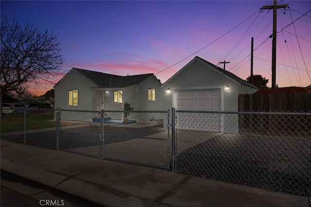 view of front of property featuring a fenced front yard, stucco siding, concrete driveway, and a gate