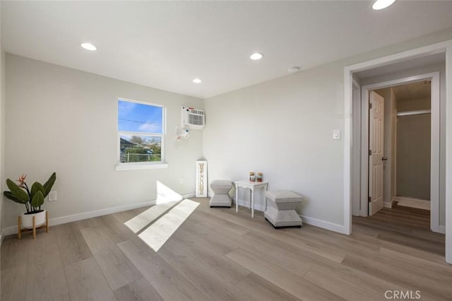 interior space with light wood-style flooring, recessed lighting, baseboards, and a wall mounted AC