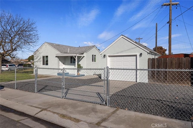 view of front facade with a fenced front yard, concrete driveway, stucco siding, a garage, and a gate