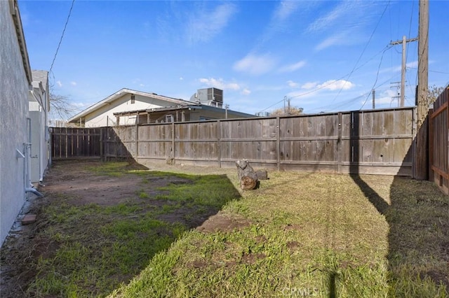 view of yard with central AC and a fenced backyard