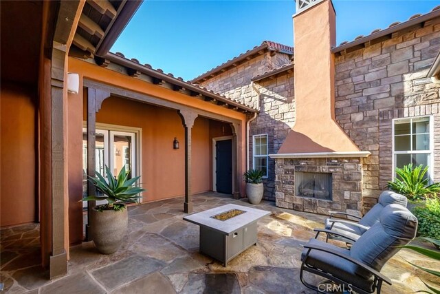 view of patio with french doors and an outdoor stone fireplace