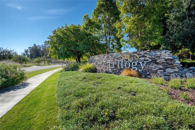 community / neighborhood sign featuring a lawn