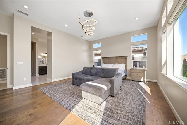 bedroom with recessed lighting, wood finished floors, visible vents, and baseboards