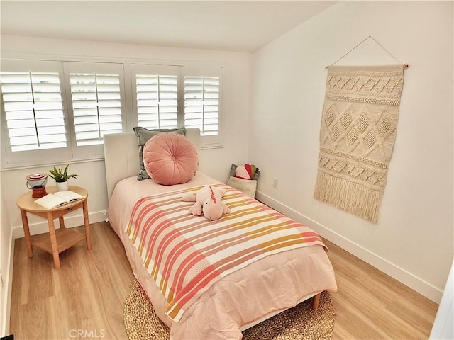 bedroom featuring baseboards and light wood-style flooring