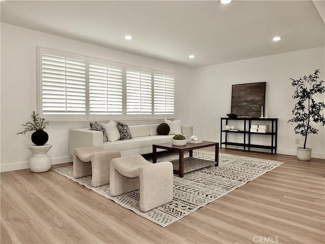 living room with recessed lighting, baseboards, and wood finished floors