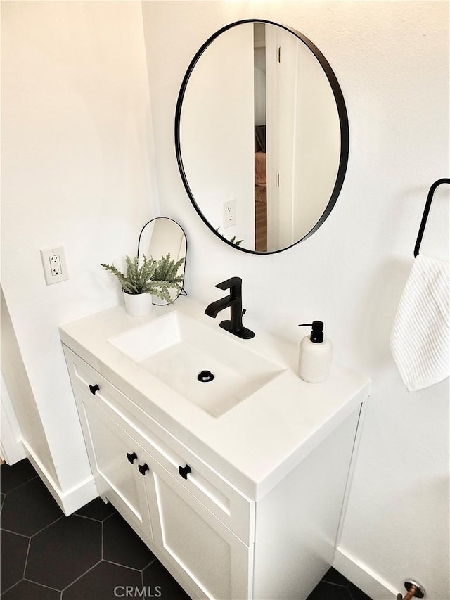 bathroom with vanity, tile patterned floors, and baseboards