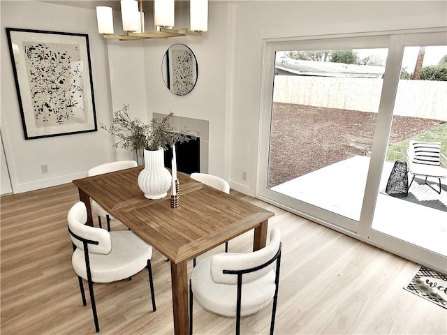 dining area with a wealth of natural light, baseboards, and light wood finished floors