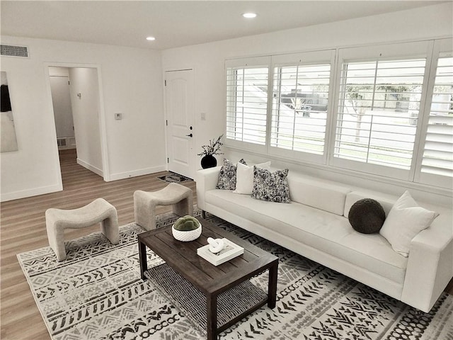 living area featuring recessed lighting, visible vents, baseboards, and wood finished floors