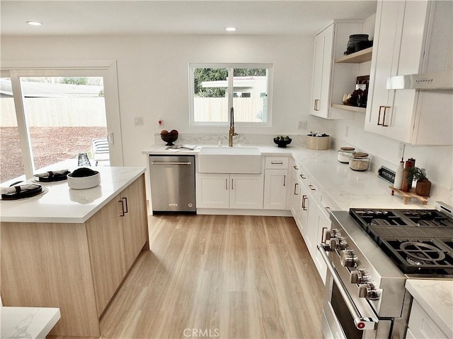 kitchen featuring plenty of natural light, appliances with stainless steel finishes, open shelves, and a sink