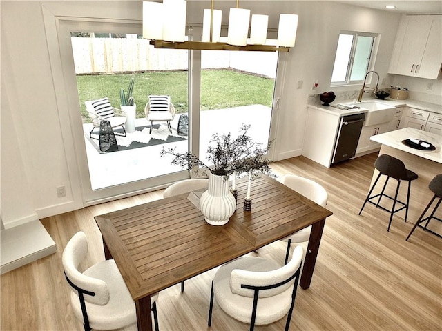 dining space with light wood-style flooring and baseboards