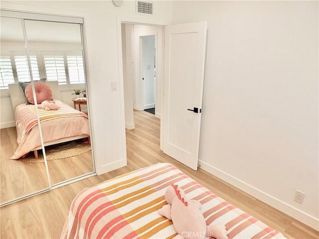 bedroom featuring wood finished floors, visible vents, and baseboards