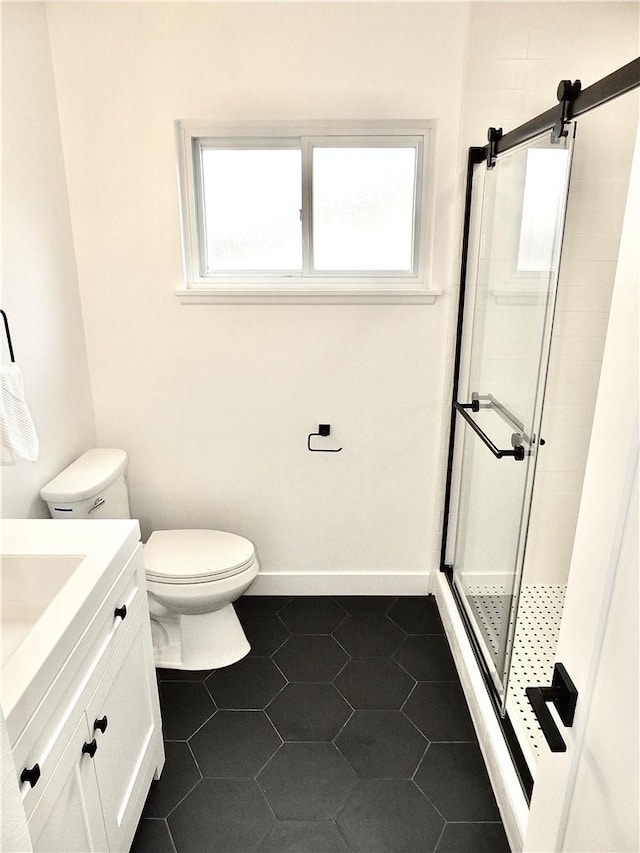 full bath with vanity, baseboards, tile patterned flooring, a shower stall, and toilet