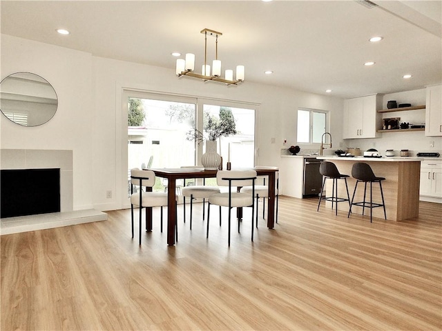 dining room with recessed lighting, an inviting chandelier, and light wood-style floors