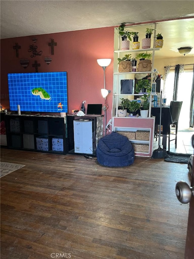 living area featuring a textured ceiling and wood finished floors