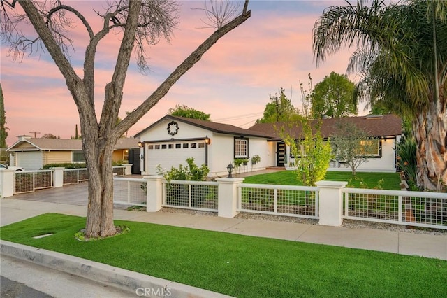 ranch-style home featuring concrete driveway, a front lawn, and a fenced front yard