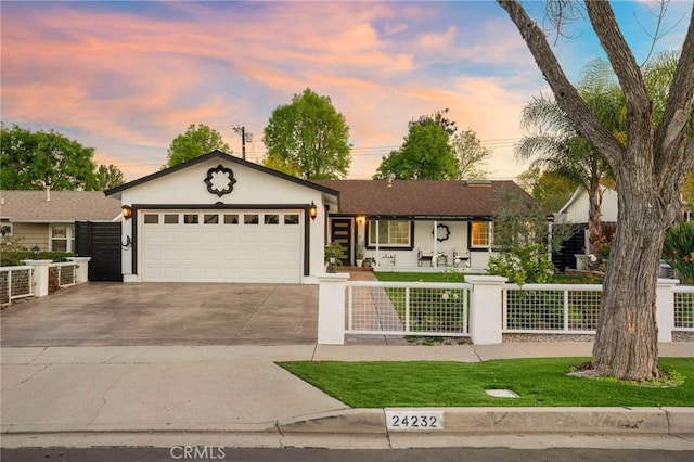 ranch-style home featuring a fenced front yard, stucco siding, driveway, and an attached garage