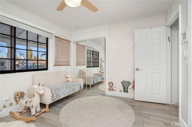 bedroom with ceiling fan, a closet, baseboards, and wood finished floors