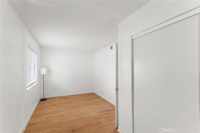 empty room with light wood-type flooring and baseboards