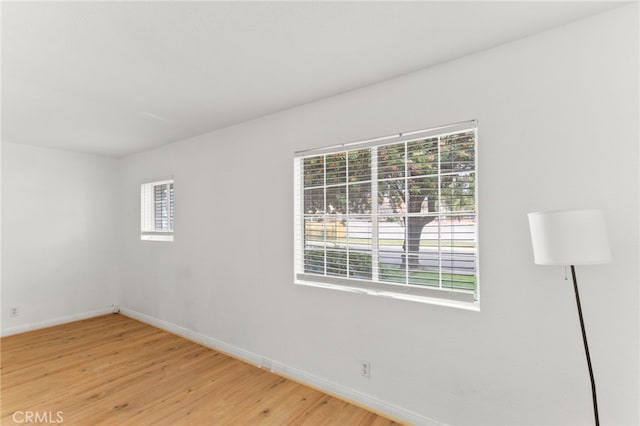 spare room with light wood-style flooring and baseboards