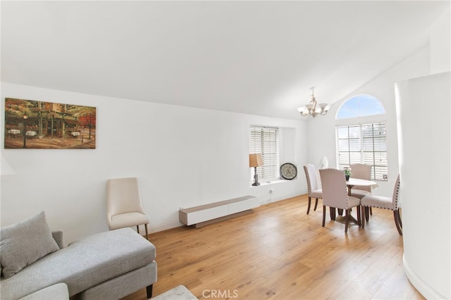 interior space featuring baseboards, vaulted ceiling, baseboard heating, light wood-style flooring, and an inviting chandelier