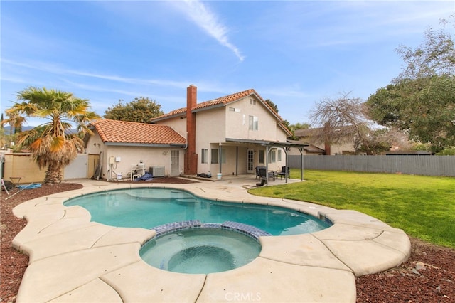 view of pool featuring a pool with connected hot tub, a lawn, cooling unit, a fenced backyard, and a patio