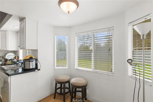 dining area featuring light wood-style flooring and baseboards