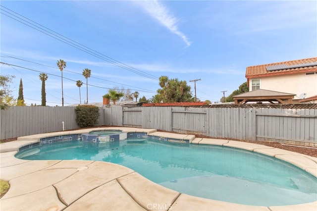 view of swimming pool featuring a patio area, a pool with connected hot tub, and a fenced backyard