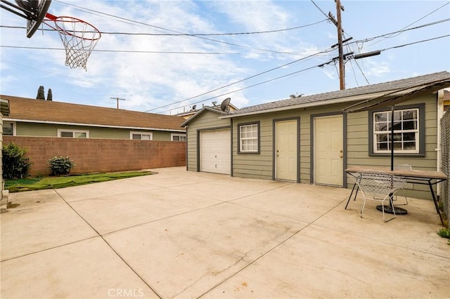 view of patio with concrete driveway and fence