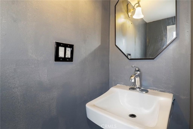 bathroom with a textured wall and a sink