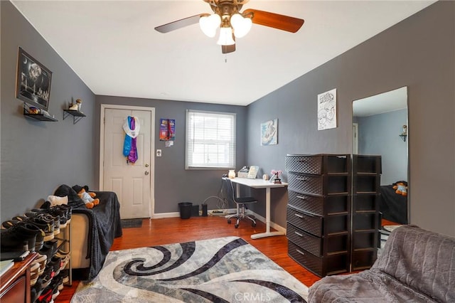 bedroom featuring baseboards, wood finished floors, and a ceiling fan