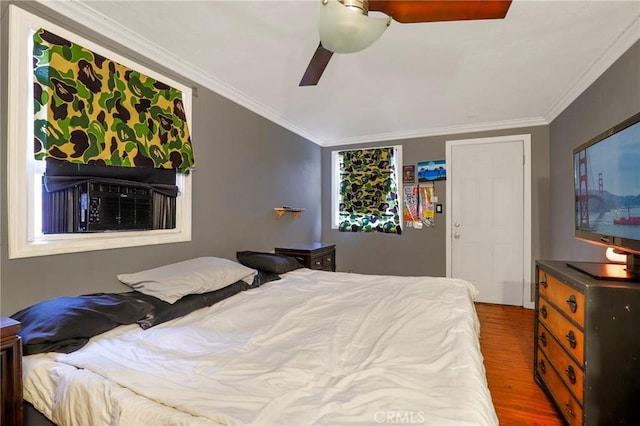 bedroom with crown molding, cooling unit, wood finished floors, and ceiling fan