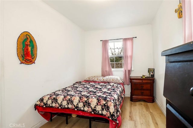 bedroom featuring baseboards and wood finished floors