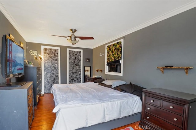 bedroom featuring ornamental molding, a ceiling fan, and wood finished floors