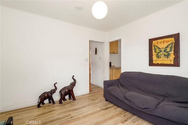 living area featuring baseboards and light wood-style flooring