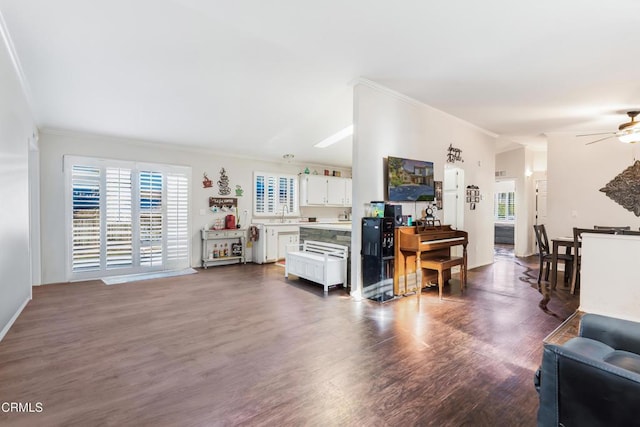 living room featuring ornamental molding, a ceiling fan, and dark wood-style flooring