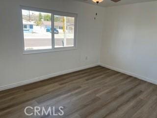 empty room with baseboards and wood finished floors