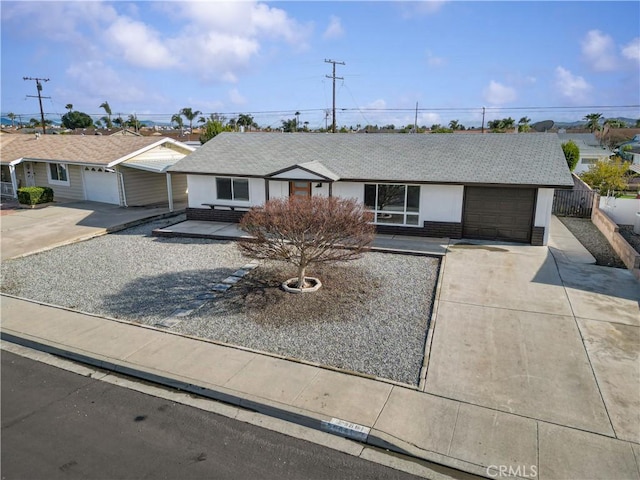 ranch-style house with brick siding, an attached garage, concrete driveway, and fence