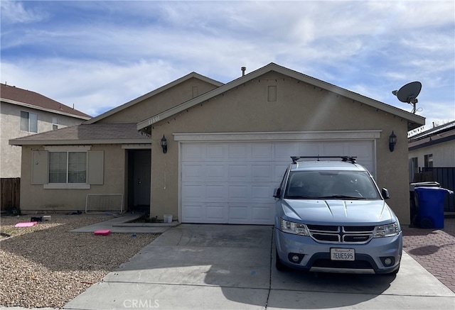 ranch-style home featuring concrete driveway, an attached garage, fence, and stucco siding