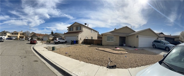 view of front of home with a residential view, stucco siding, concrete driveway, and fence