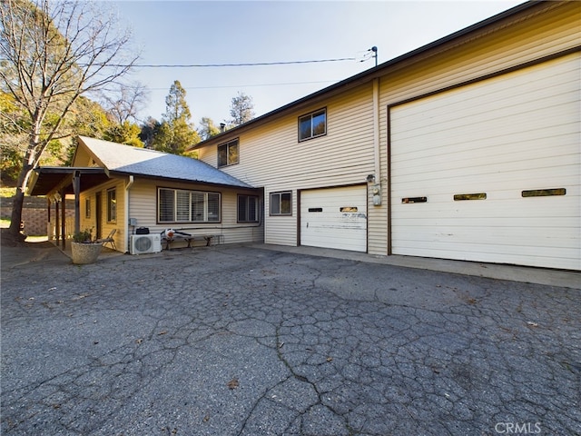 view of front of home with ac unit and aphalt driveway