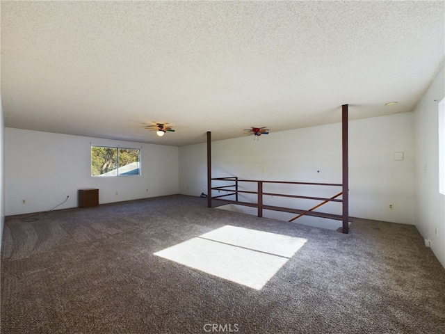 spare room featuring carpet flooring and a textured ceiling