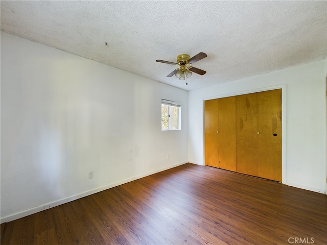 unfurnished bedroom featuring wood finished floors, baseboards, a closet, and a textured ceiling