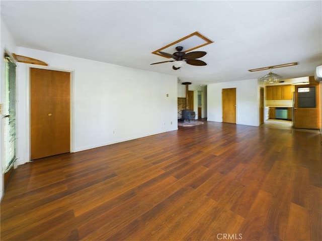 unfurnished living room with dark wood-style floors, a wood stove, and ceiling fan