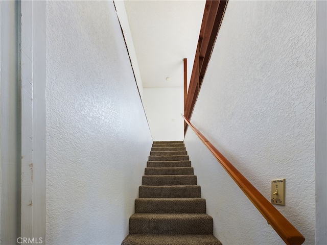 staircase featuring a textured wall