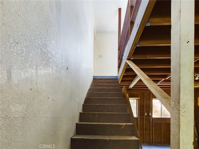 staircase featuring a textured wall