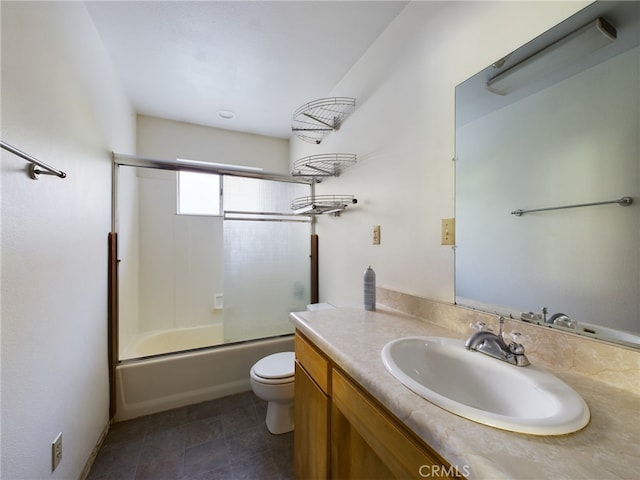 bathroom featuring vanity, toilet, and combined bath / shower with glass door