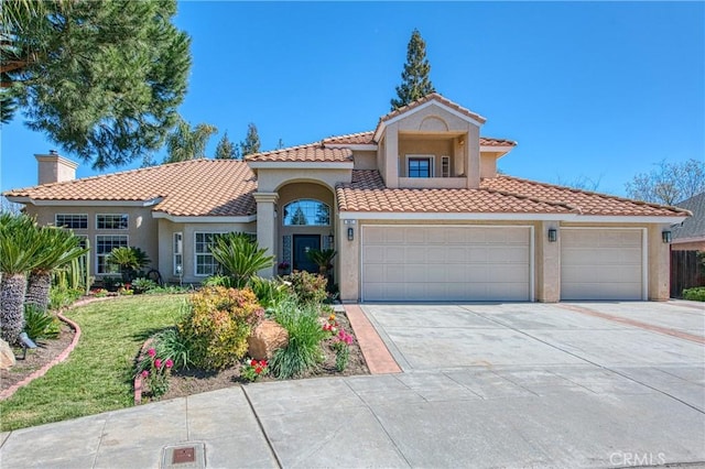 mediterranean / spanish home with a tiled roof, concrete driveway, stucco siding, a chimney, and an attached garage